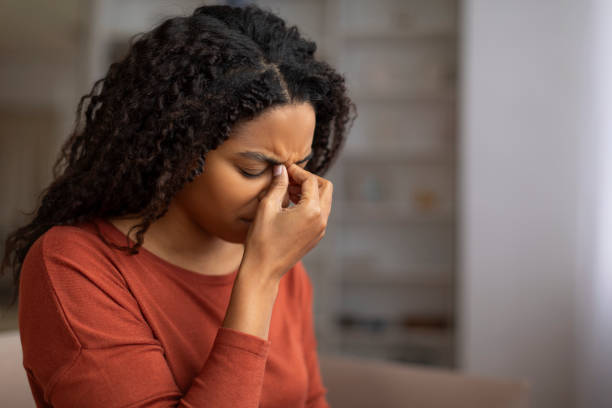 istock Young black woman feeling sinus pain, pressing on the nose bridge 2156287721