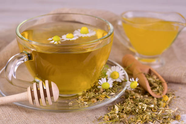 istock Herbal chamomile tea with honey, and medicinal chamomile flowers. Close-up. 2156289453