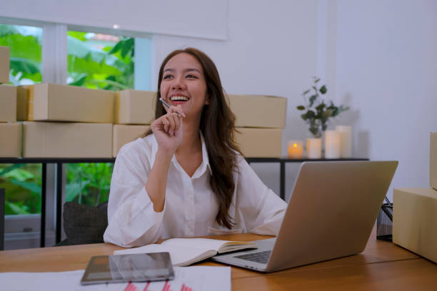 istock Young female entrepreneur is packing merchandise  at home. 2156289524