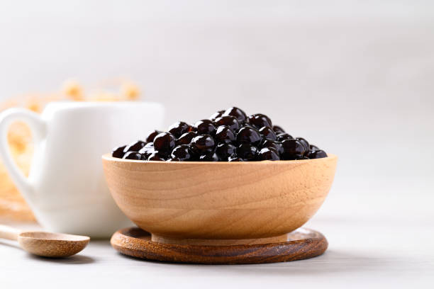 istock Black tapioca pearls or boba in wooden bowl, Ingredient in bubble tea 2156291065