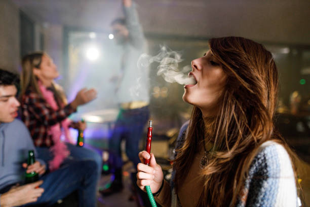 istock Young woman smoking hookah during a party at home. 2156293463