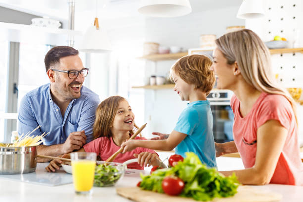 istock Young happy family talking while preparing a meal in the kitchen. 2156293697