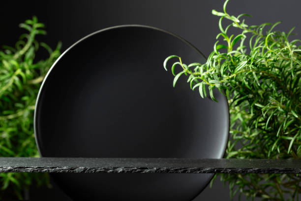 istock Black stone podium, black ceramic plate and branches of rosemary. 2156294334