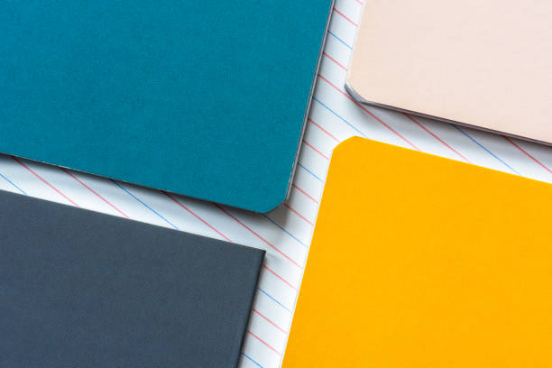 istock Colorful notebooks lie on a lined paper background 2156295486