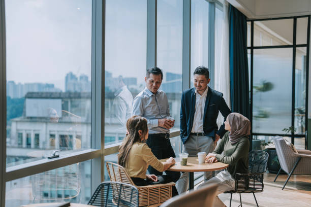 istock Coffee break Asian white collar colleague discussion with window background 2156295601