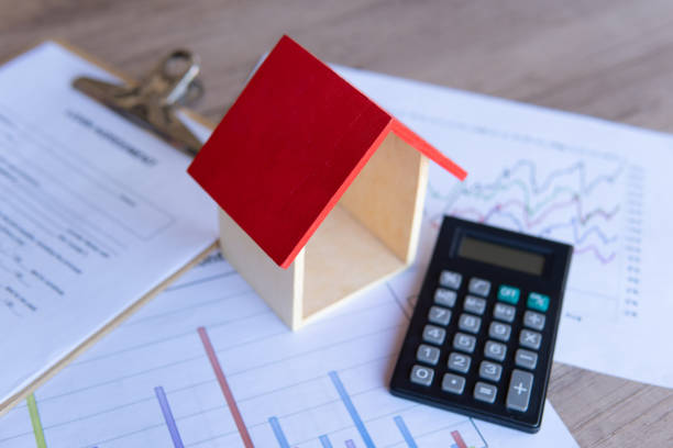 istock Wooden toy house, calculator and graph. 2156297089