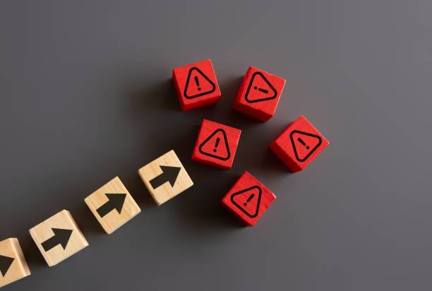 istock Wooden blocks with upward arrow and warning icon. 2156297736