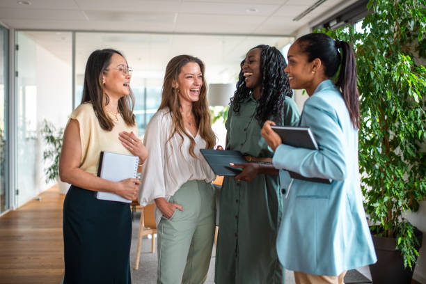 istock Diverse Businesswomen Using Tablet in Office Hallway 2156299234