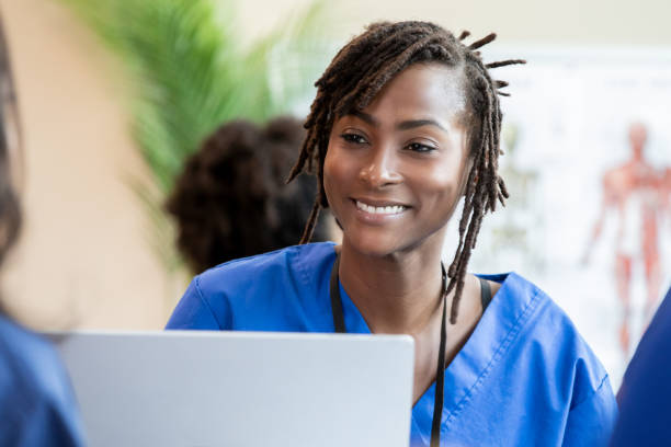 istock In a classroom setting, a nursing student in scrubs multitasks by participating in the discussion and typing lecture notes on her laptop. 2156299833