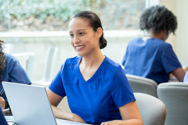 istock In class, a diligent nursing student in scrubs actively contributes to the discussion and takes notes on her laptop. 2156299842