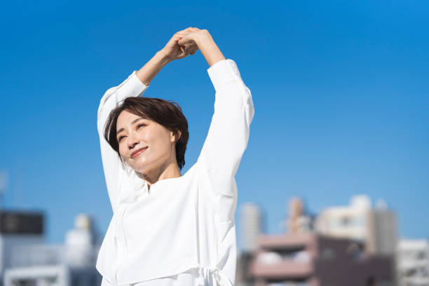中年の日本人女性が空を見上げている。 - のびる ストックフォトと画像