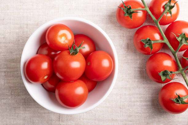 istock Red cherry tomatoes, small cocktail tomatoes in a white bowl on linen 2156300028