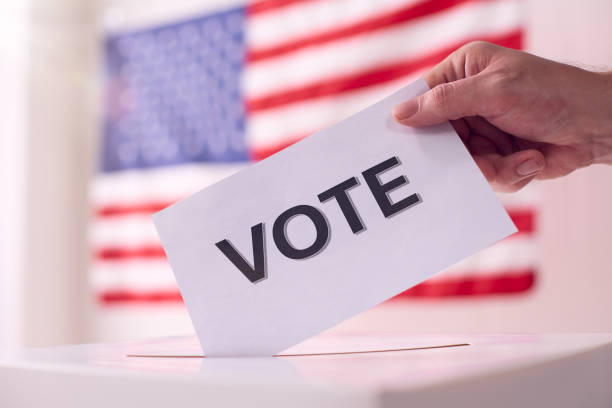 istock Casting a Vote in Front of the American Flag 2156303179