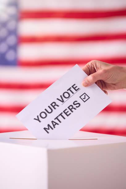 istock Hand Placing Ballot Into Box With American Flag 2156303807