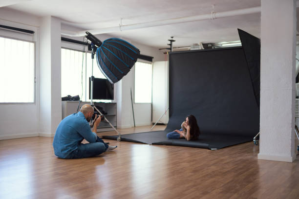 istock Photographer capturing a woman posing in a studio setting 2156304068