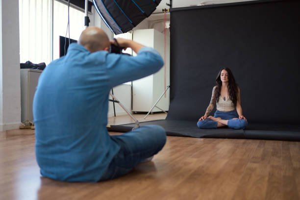 istock Photographer capturing woman meditating in studio setting 2156304133