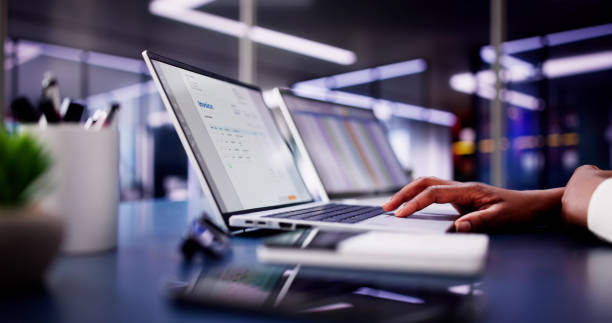 istock African American woman working on electronic invoices on multiple computer screens in accounting office 2156307954