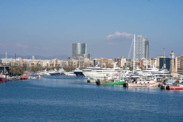 Barcelona, Spain - May 29, 2017: Big Mediterranean skies over the crowded marina of luxury yachts and motor boats beside the fashionable Barceloneta waterfront of Port Vell, Barcelona, Spain.