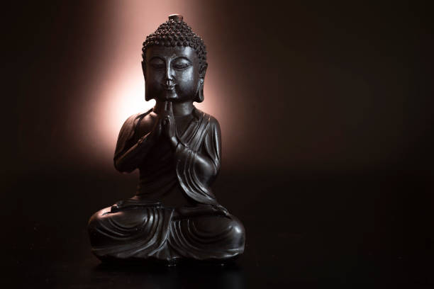 istock Buddha in atmospheric dark lighting with side light and selective focus 2156313097