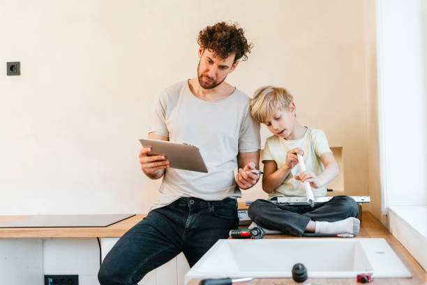 istock Father and son assembling kitchen furniture 2156317383