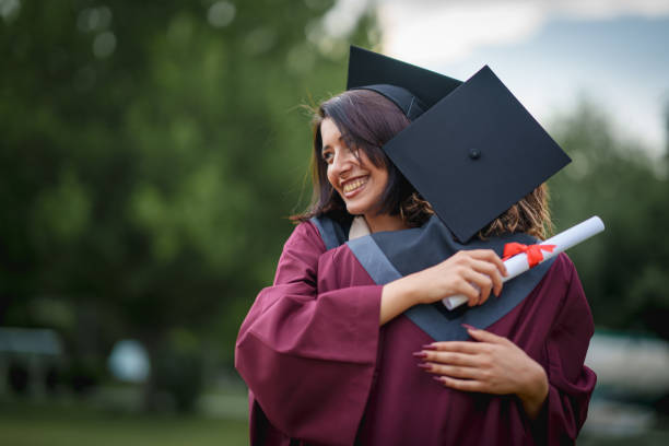 istock Graduate students  embracing on graduation day. 2156317481
