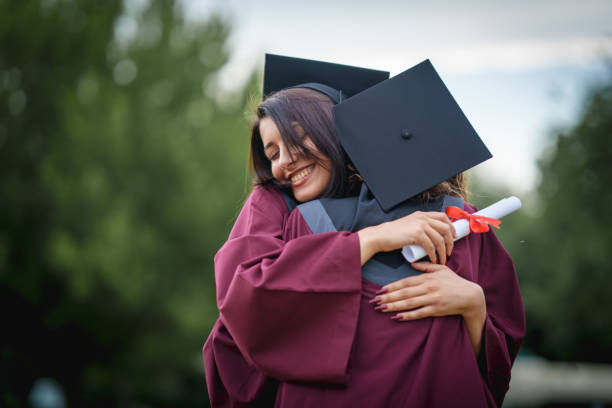 istock Graduate students  embracing on graduation day. 2156317510
