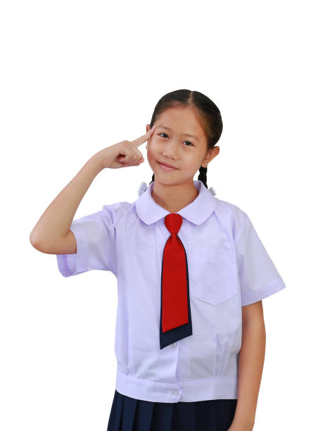 Asian student girl in elementary school uniform think for new idea gesture with index finger point brain head standing isolated on white background. Image with clipping path.