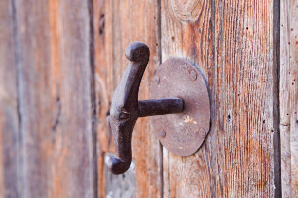 An old rusty metal hinge at the wooden door