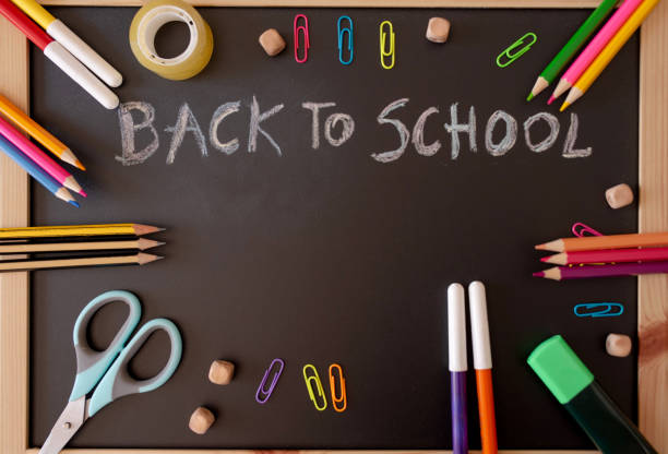 istock School supplies on black board background, back to school concept 2156323192