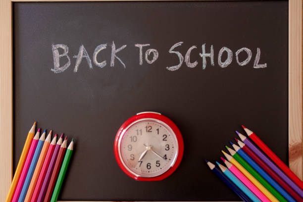 Close-up of yellow pencil with Back to School sign speech bubble against white background.