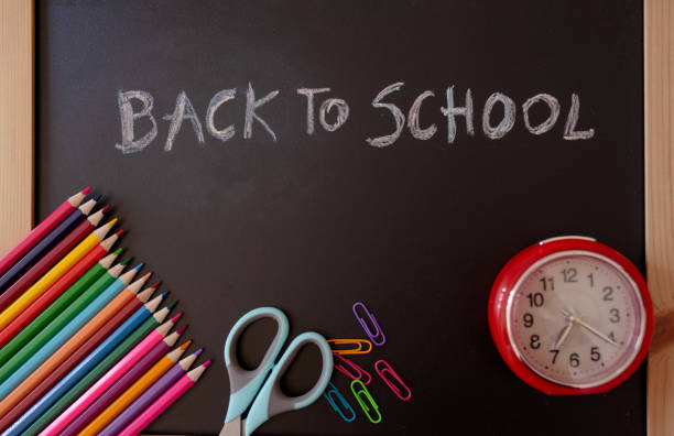 istock back to School words on blackboard with colorful pencils, scissors and a clock 2156323222