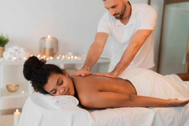istock Massage therapist assisting spa client African American woman 2156323683