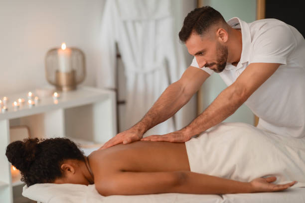 istock Massage therapist working on African American lady 2156323727