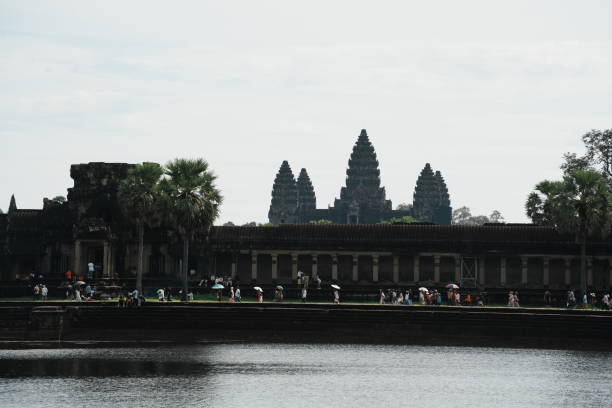 Tourists sightseeing at the majestic Angkor Wat temple, Cambodia. It's the largest religious monument in the world by land area.