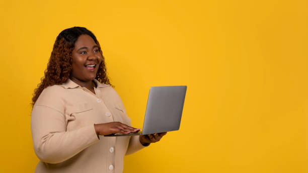 istock Positive chubby african american woman using laptop 2156324254