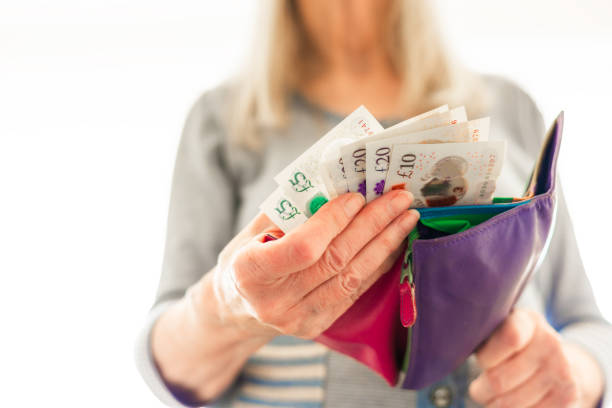 istock Senior woman taking bank notes from her wallet 2156324361