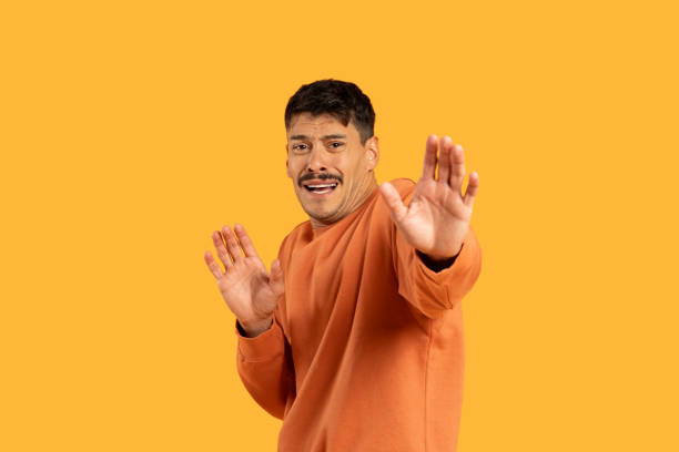 istock Man Standing in Front of Yellow Background 2156329630