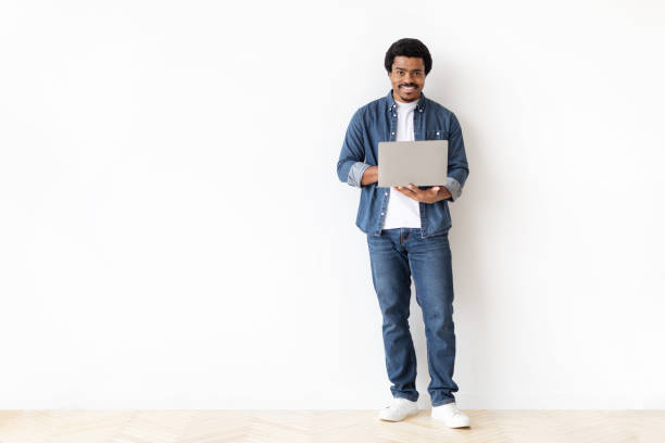 istock Engaged young black man holding laptop with pleasant smile 2156332319