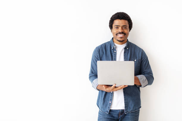 istock Handsome young black man confidently holding laptop 2156332320