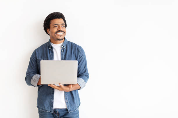 istock Smiling man holding a laptop looking away 2156332408
