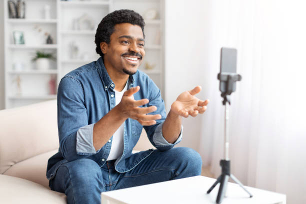 istock Man recording a video on smartphone at home 2156332754