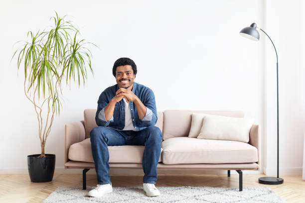istock Man Sitting on Couch in Cozy Living Room 2156332830