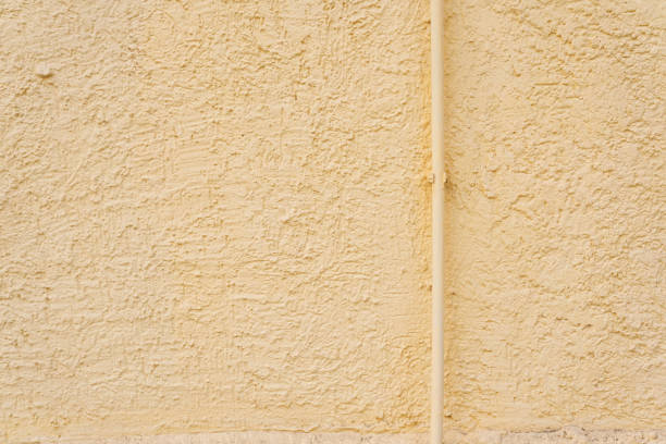 The texture of a stone yellow wall. Uneven surface background with space to copy. High quality photo