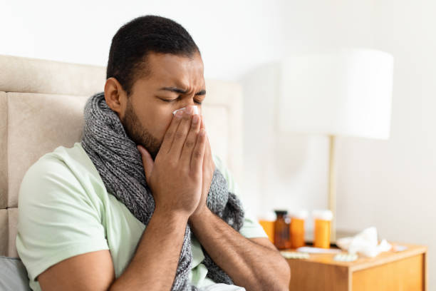 istock Man with scarf looking ill, sneezing 2156334309