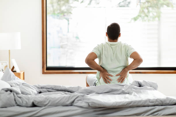 istock Tired black man suffering from back pain after waking up 2156334391