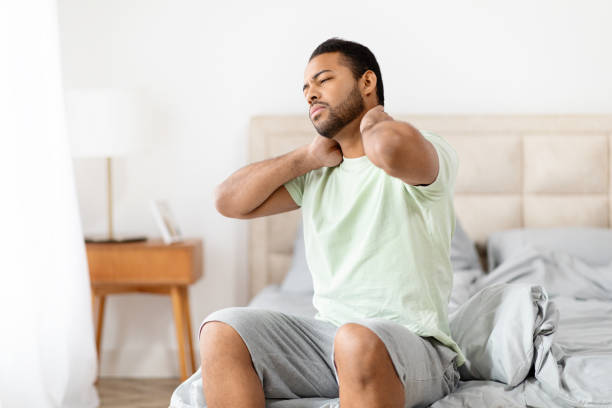 istock Unhappy black guy suffering from neck pain after waking up 2156334401