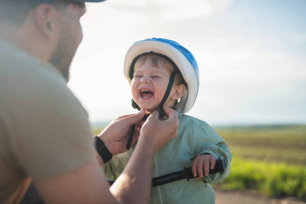 Father preparing his little boy for a bicycle ride.