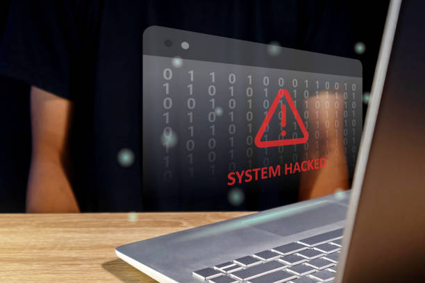 istock Hacker or cyber criminal with laptop stealing user personal data. Warning of a system hacked. Virus, malware or cyber attack. 2156337999