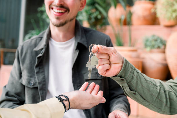 joven pareja feliz comprando una nueva casa, recibiendo llaves - jovenes vivienda fotografías e imágenes de stock