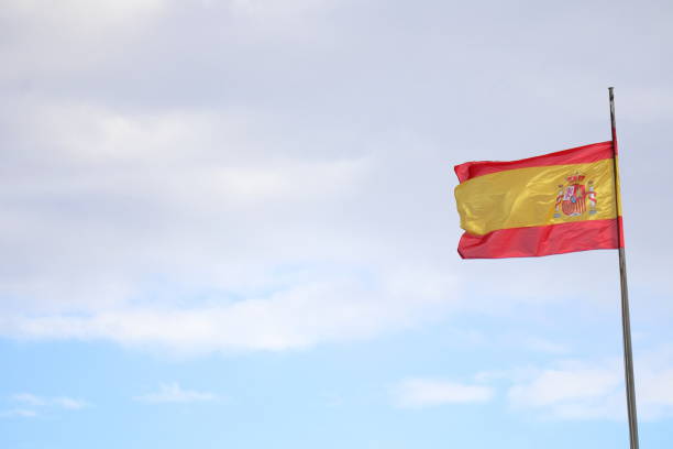 istock Spanish flag in the cloudy sky. waving in the sky 2156339823